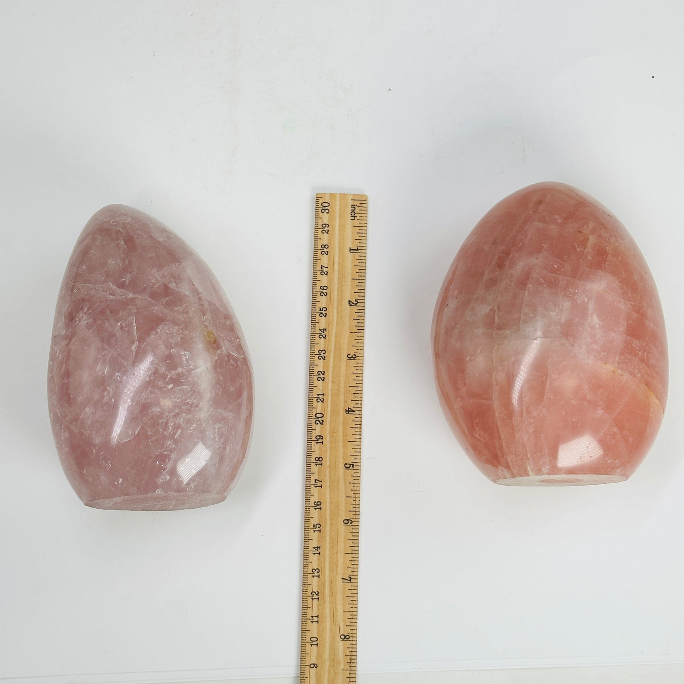 rose quartz polished cutbases next to a ruler for size reference