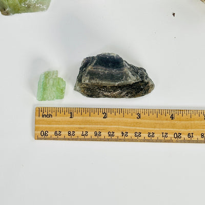 green calcite next to a ruler for size reference