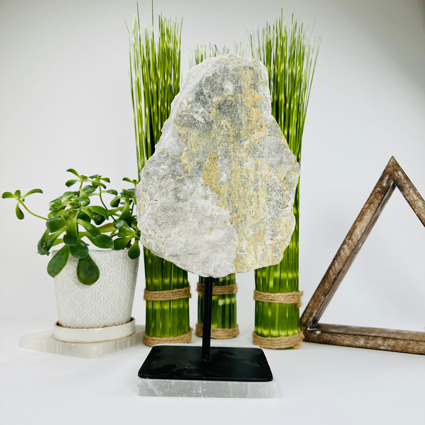 crystal quartz with sugar druzy on metal stand with decorations in the background