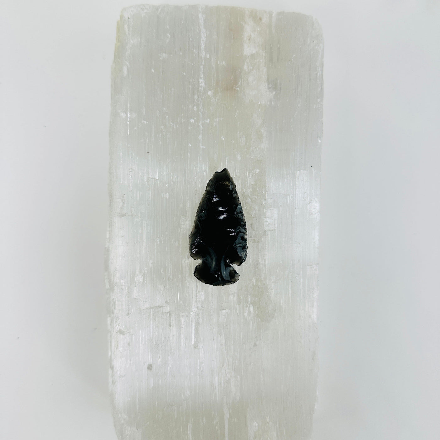 black obsidian arrowhead on selenite background
