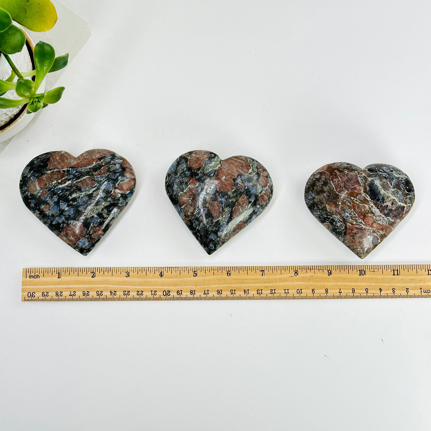 3 rhyolite hearts next to a ruler for size reference