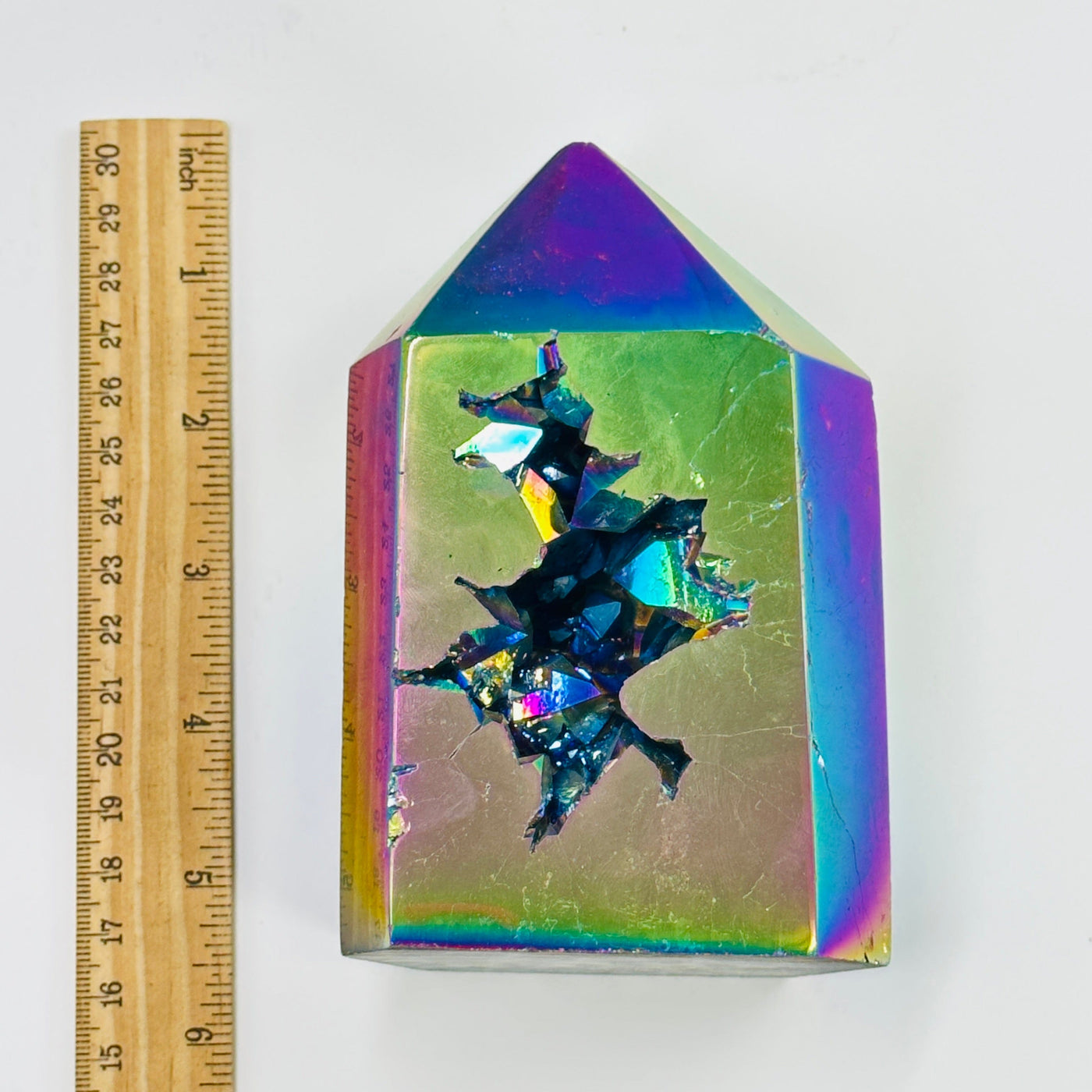 rainbow titanium coated agate point next to a ruler for size reference