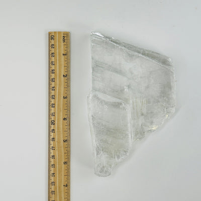 clear selenite slab next to a ruler for size reference