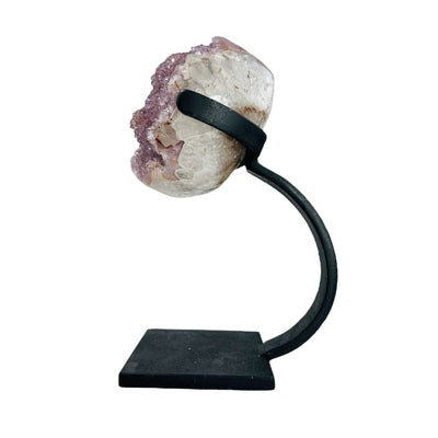 side view of polished amethyst with stand on white background