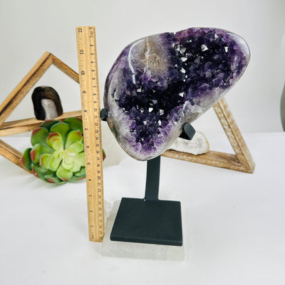 amethyst on stand next to a ruler for size reference
