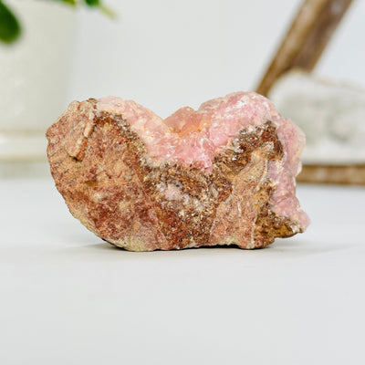 pink cobalto calcite formation with decorations in the background