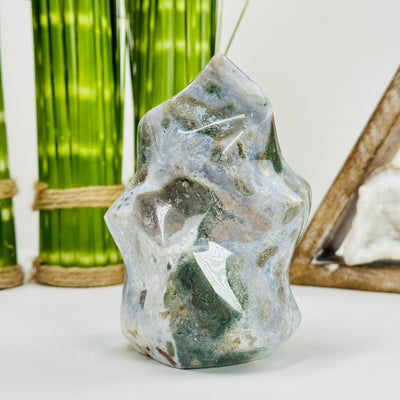 Moss agate flame tower with decorations in the background