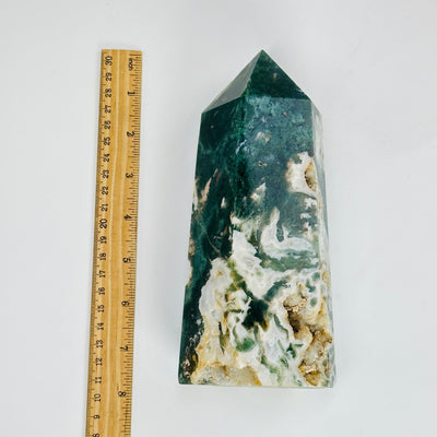 moss agate polished tower next to a ruler for size reference