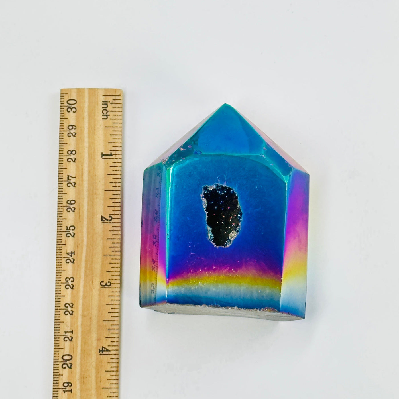 rainbow titanium agate point next to a ruler for size reference