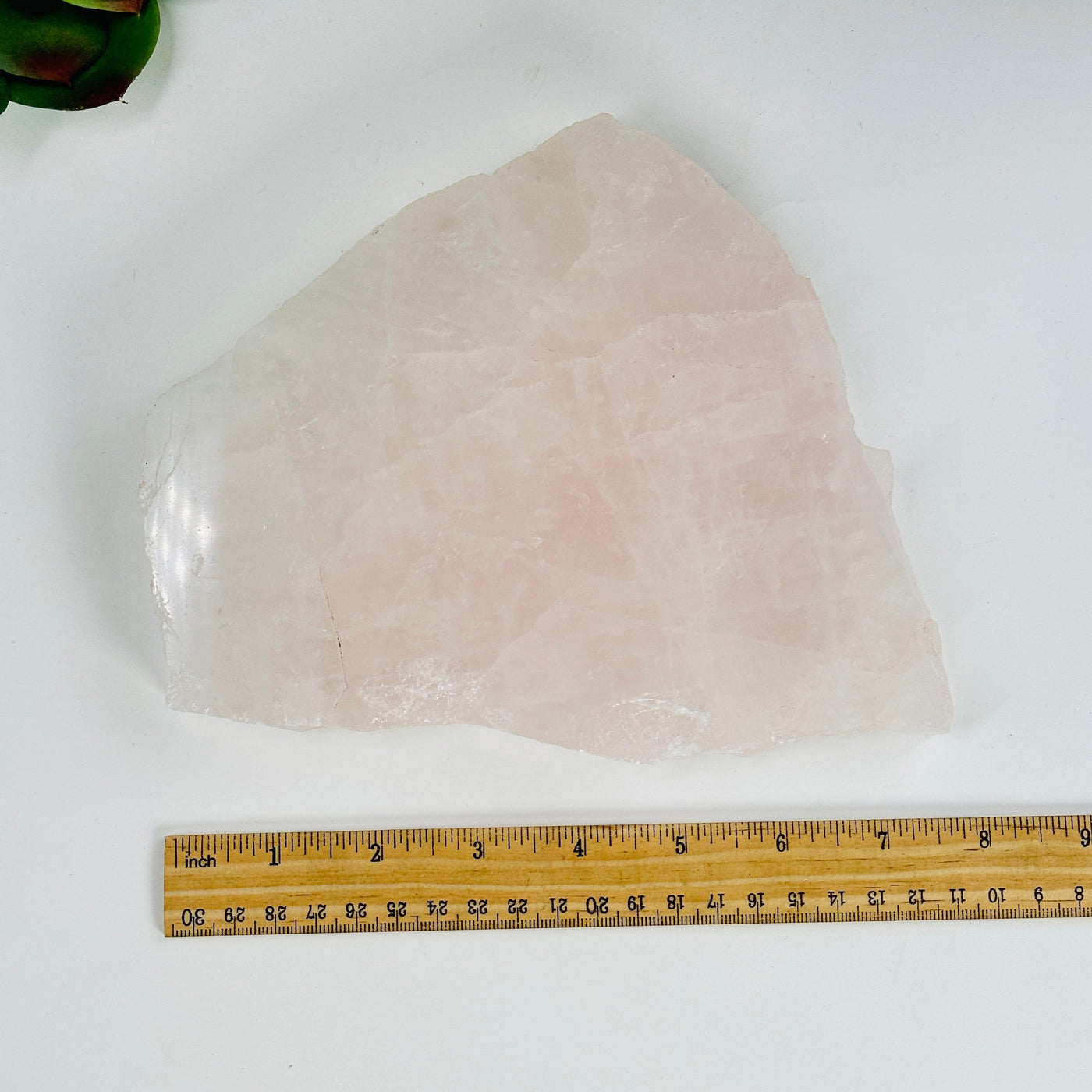rose quartz slab next to a ruler for size reference