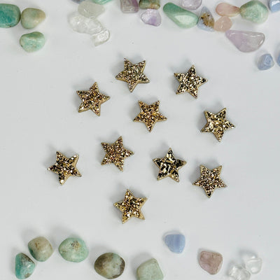gold titanium druzy star cabochons with decorations surrounding them