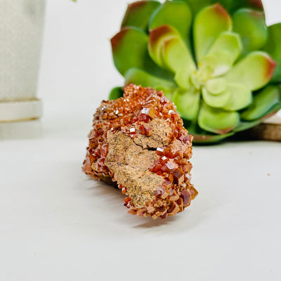 Vanadinite freeform with decorations in the background