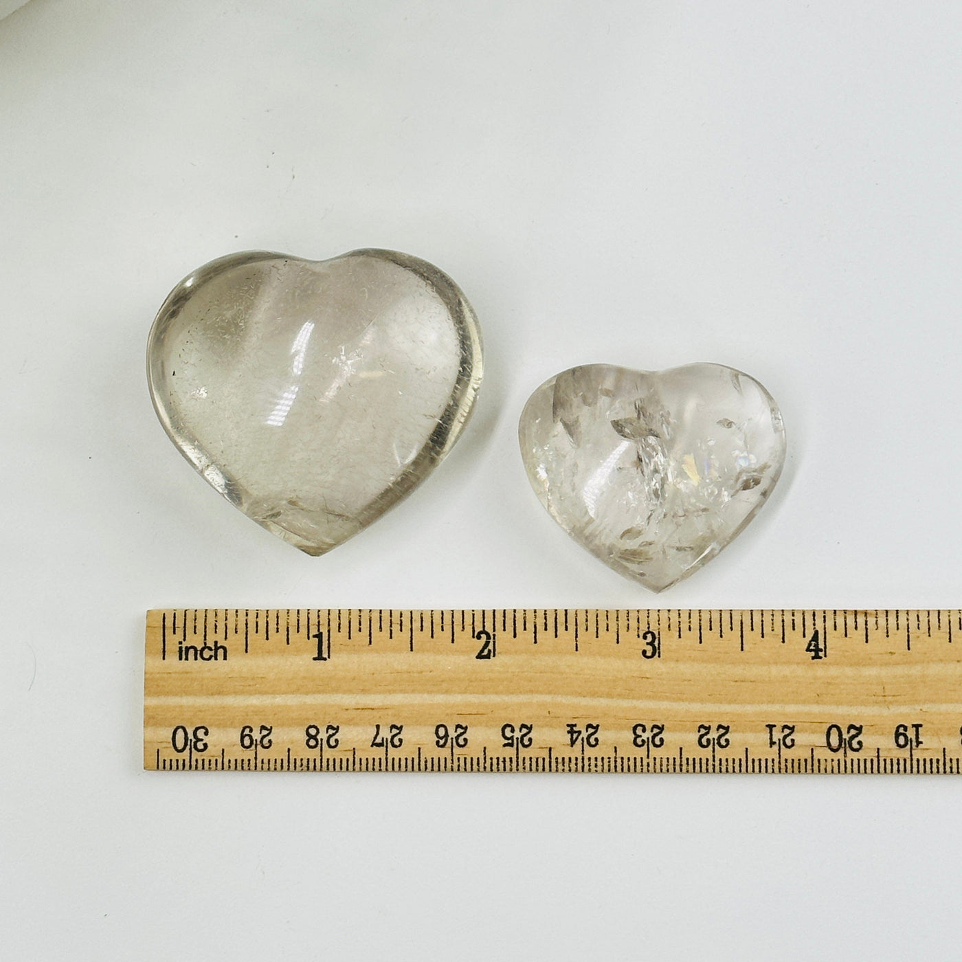 Crystal quartz hearts next to a ruler for size reference