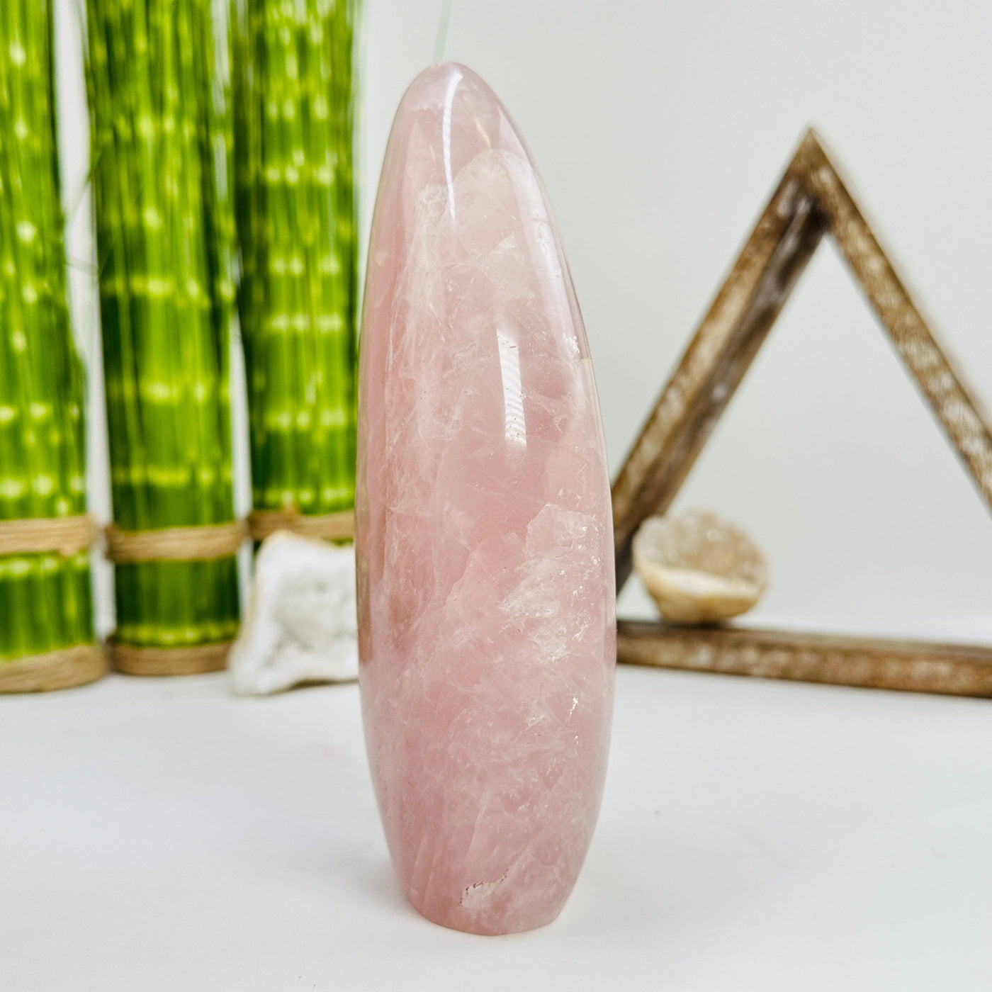 side view of rose quartz polished cutbase with decorations in the background