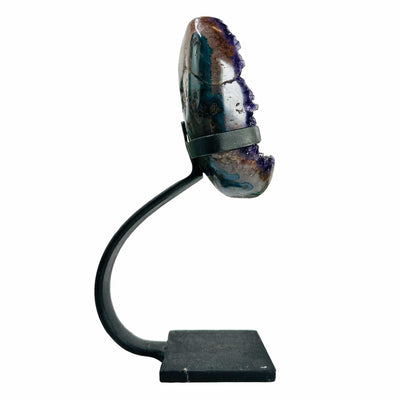 side view of polished amethyst on stand on white background