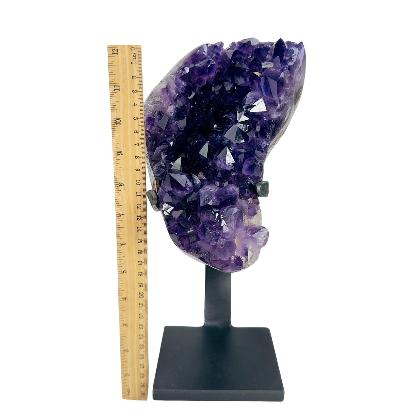 amethyst on stand next to a ruler for size reference