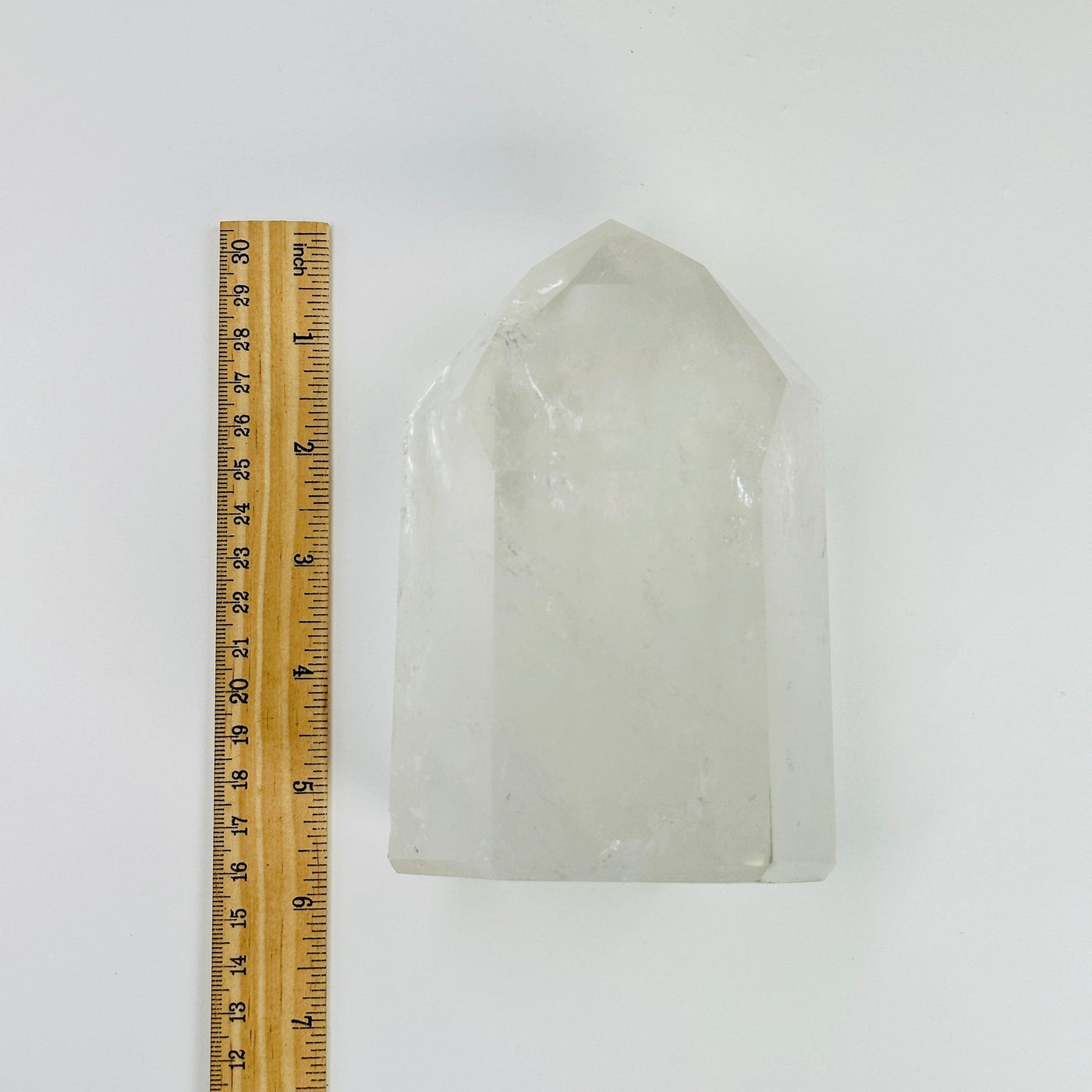 crystal quartz polished point next to a ruler for size reference