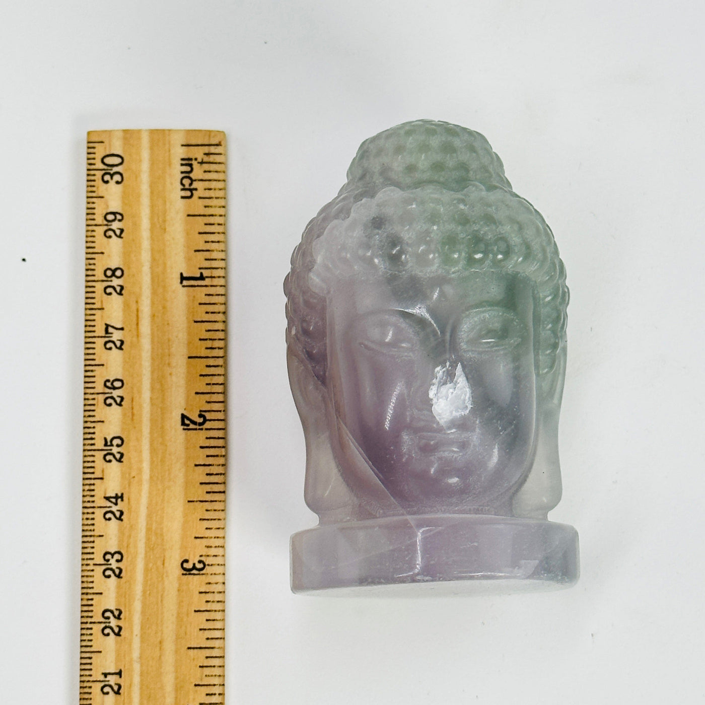 fluorite buddha head next to a ruler for size reference