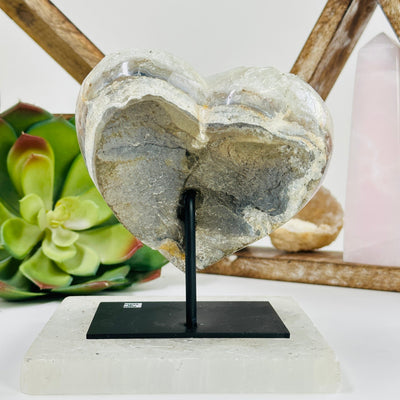 Aura amethyst heart on metal stand with decorations in the background