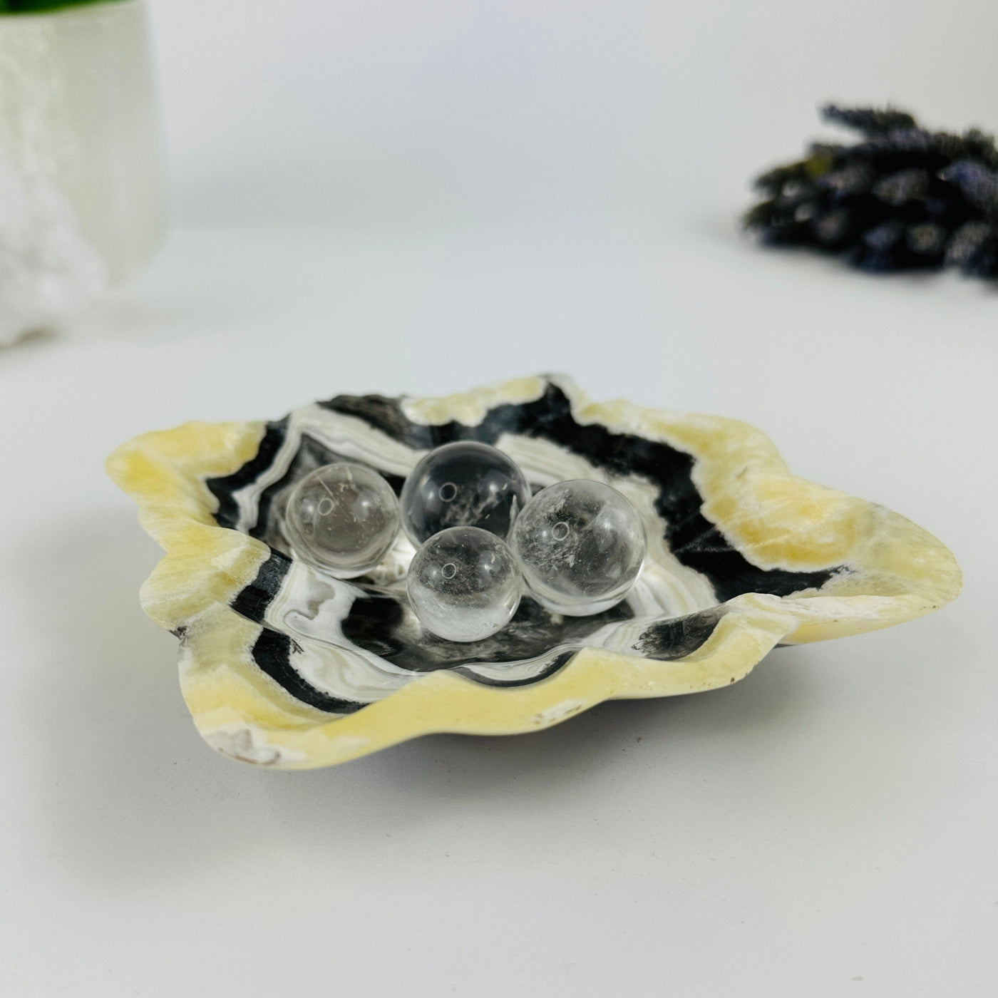 Angled shot of Mexican onyx bowl with crystals in it and decorations in the background