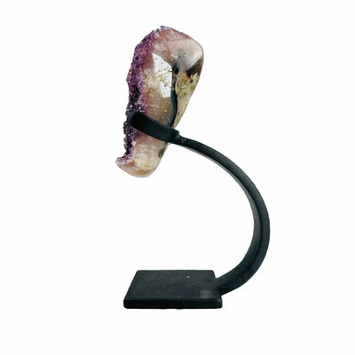 side view of polished amethyst on stand on white background