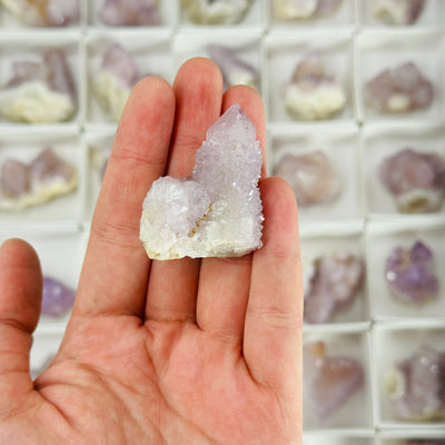 hand holding up spirit quartz with others in the background