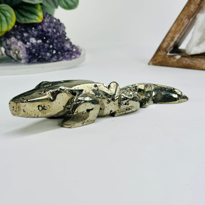 Pyrite alligator with decorations in the background