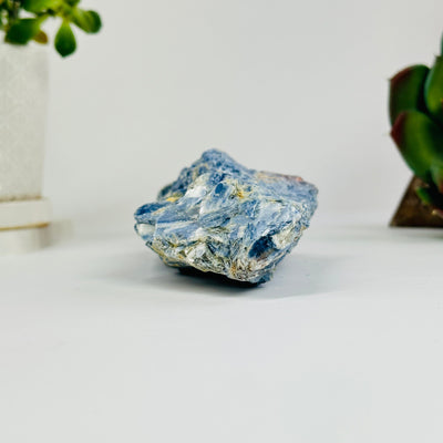 blue kyanite cluster with decorations in the background