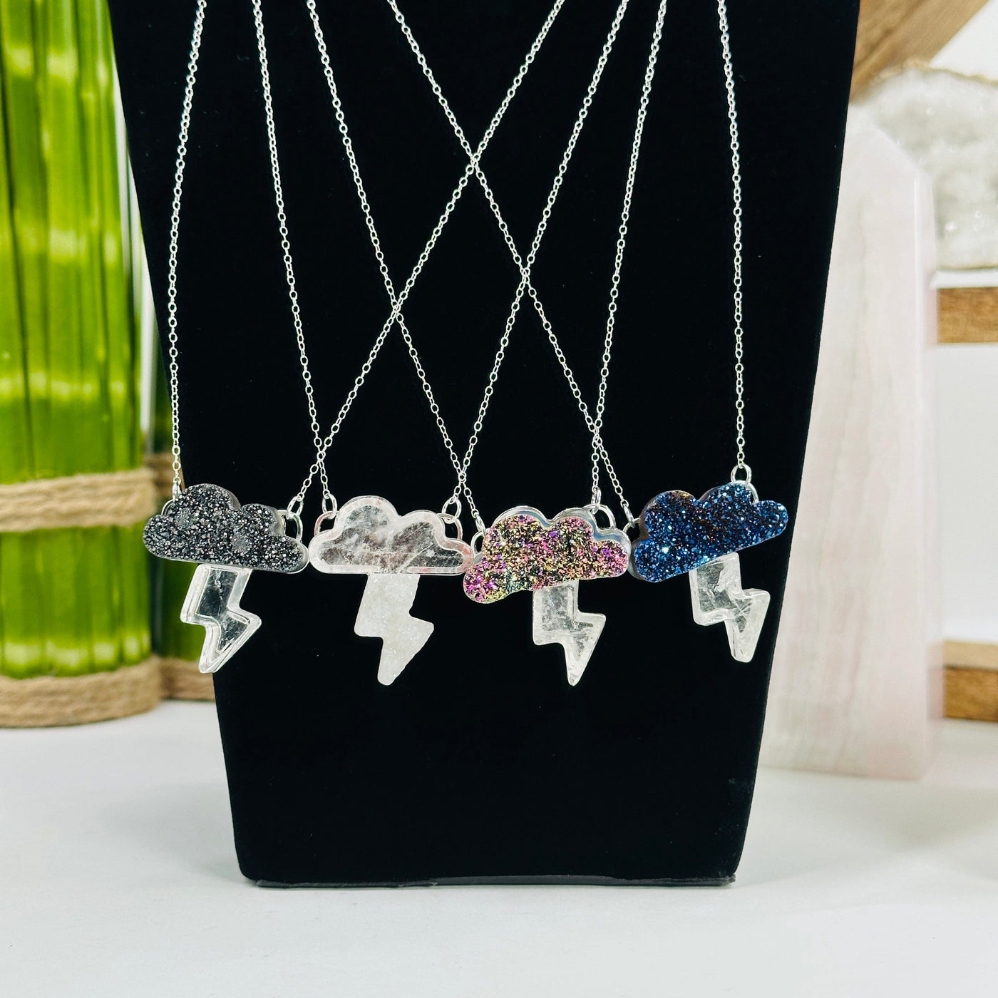 4 cloud with lightning necklaces in silver on a display