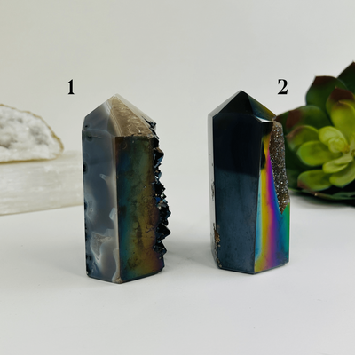 side view of Both variants of rainbow titanium coated agate point with decorations in the background