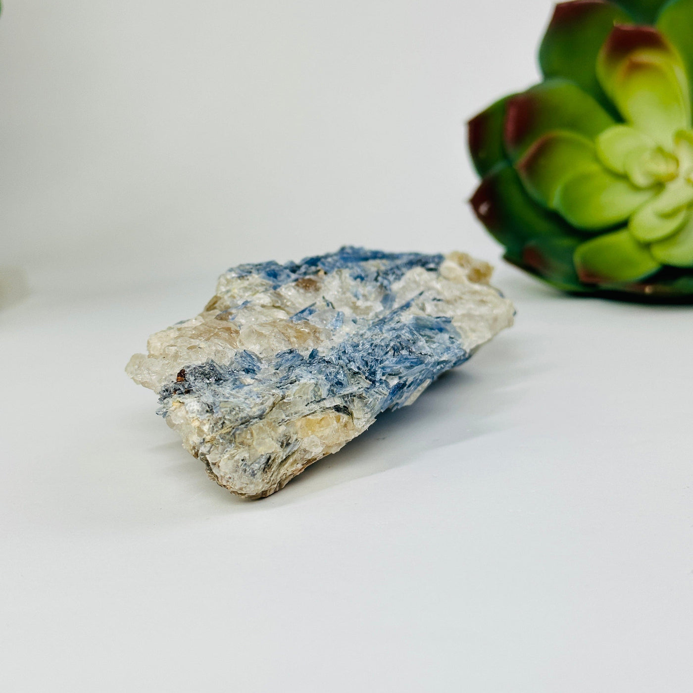 kyanite natural cluster with decorations in the background