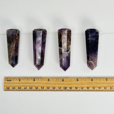amethyst obelisk points with a chain through them next to a ruler for size reference