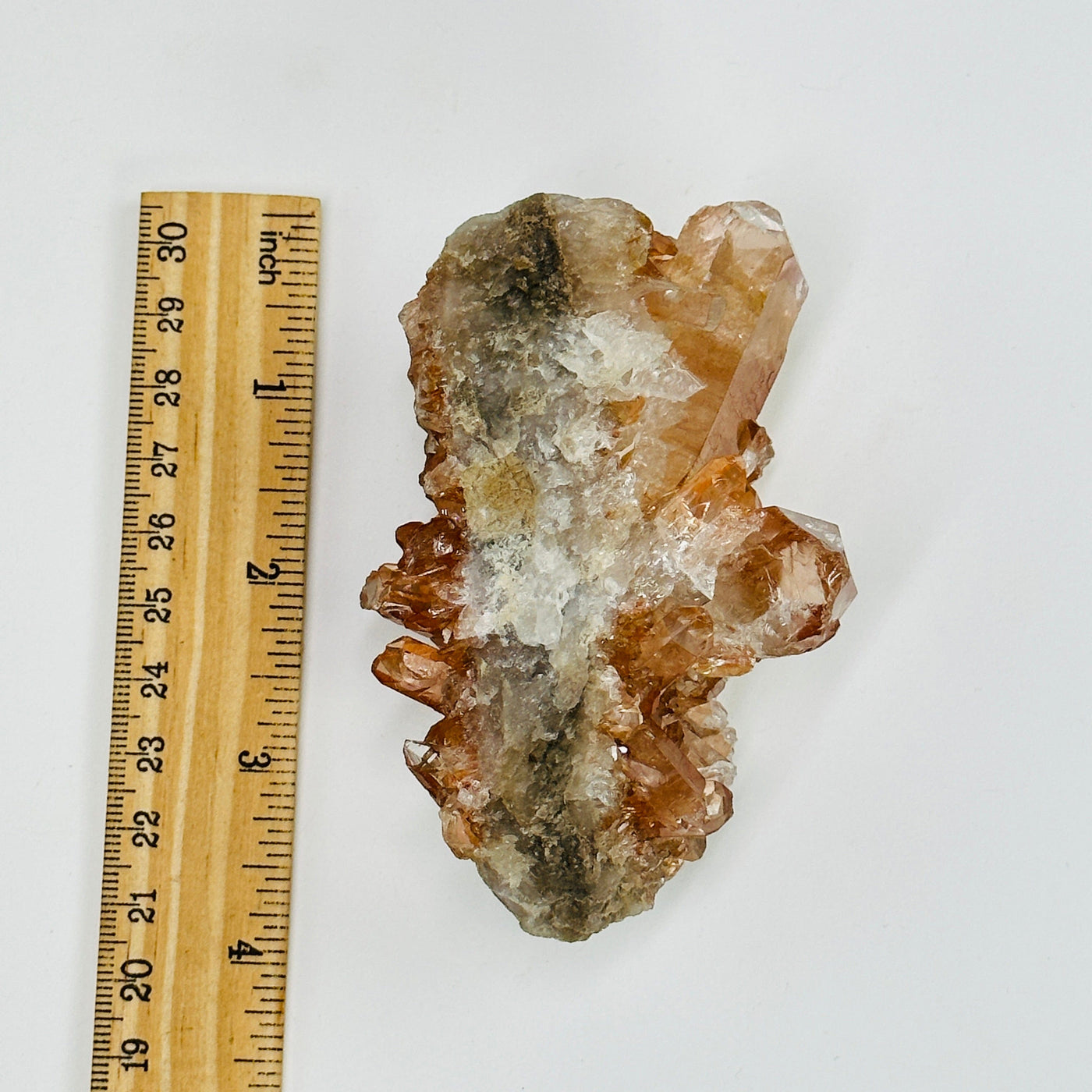 tangerine quartz cluster next to a ruler for size reference
