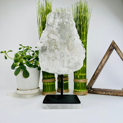 crystal quartz with sugar druzy on metal stand with decorations in the background