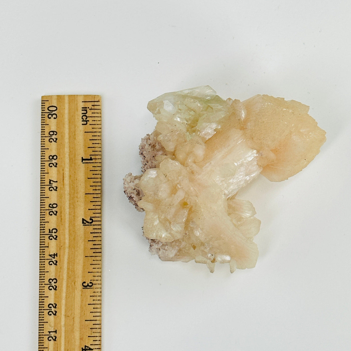 apophyllite with calcite next to a ruler for size reference