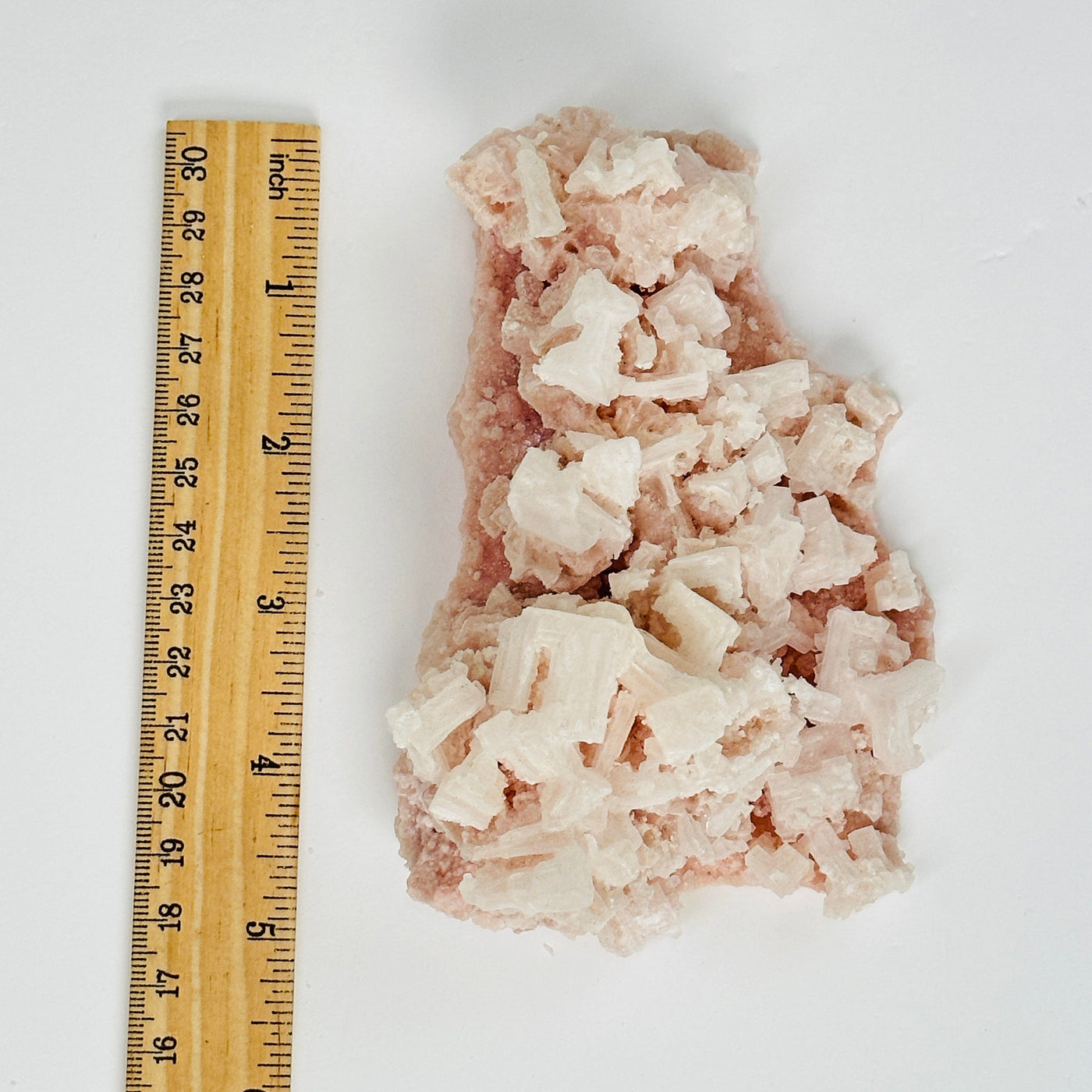 pink halite next to a ruler for size reference