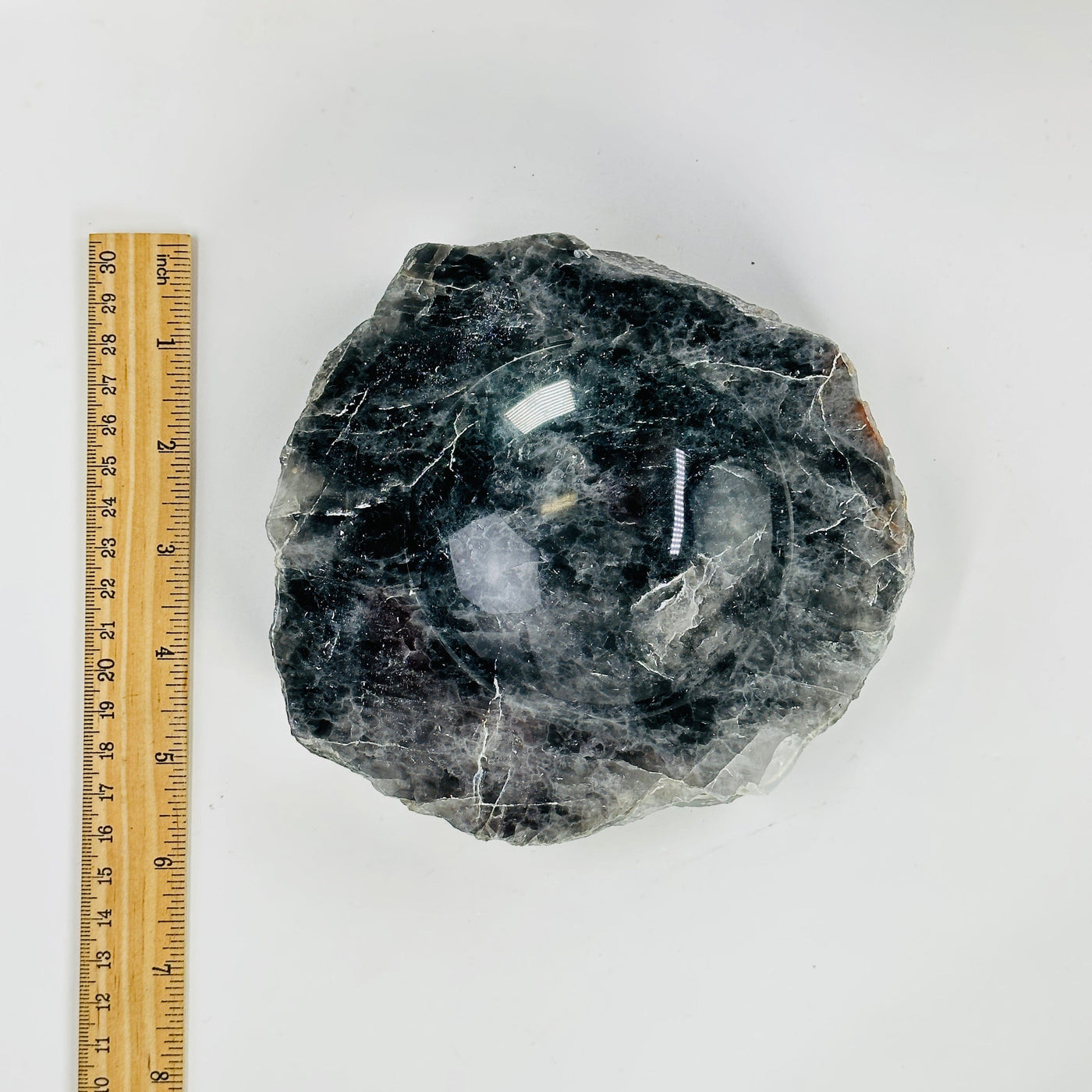 larvikite semi polished bowl next to a ruler for size reference