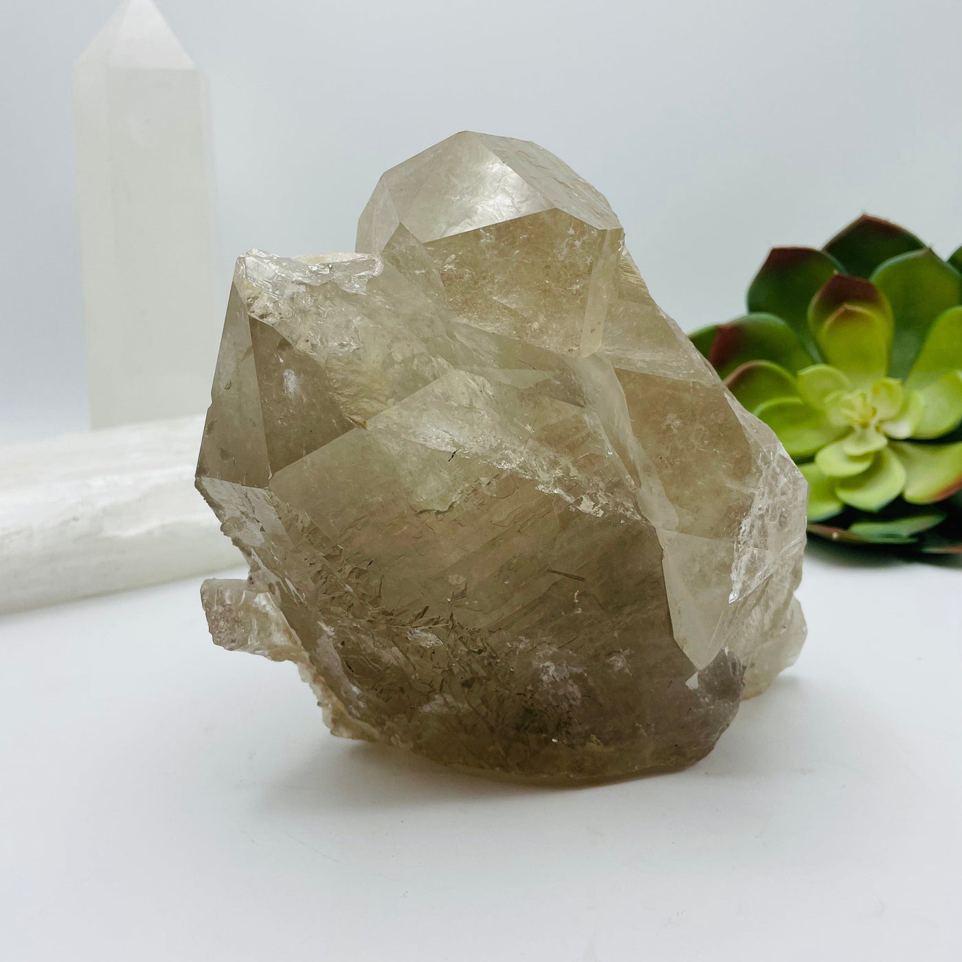 up close shot of rutilated quartz cluster with decorations in the background
