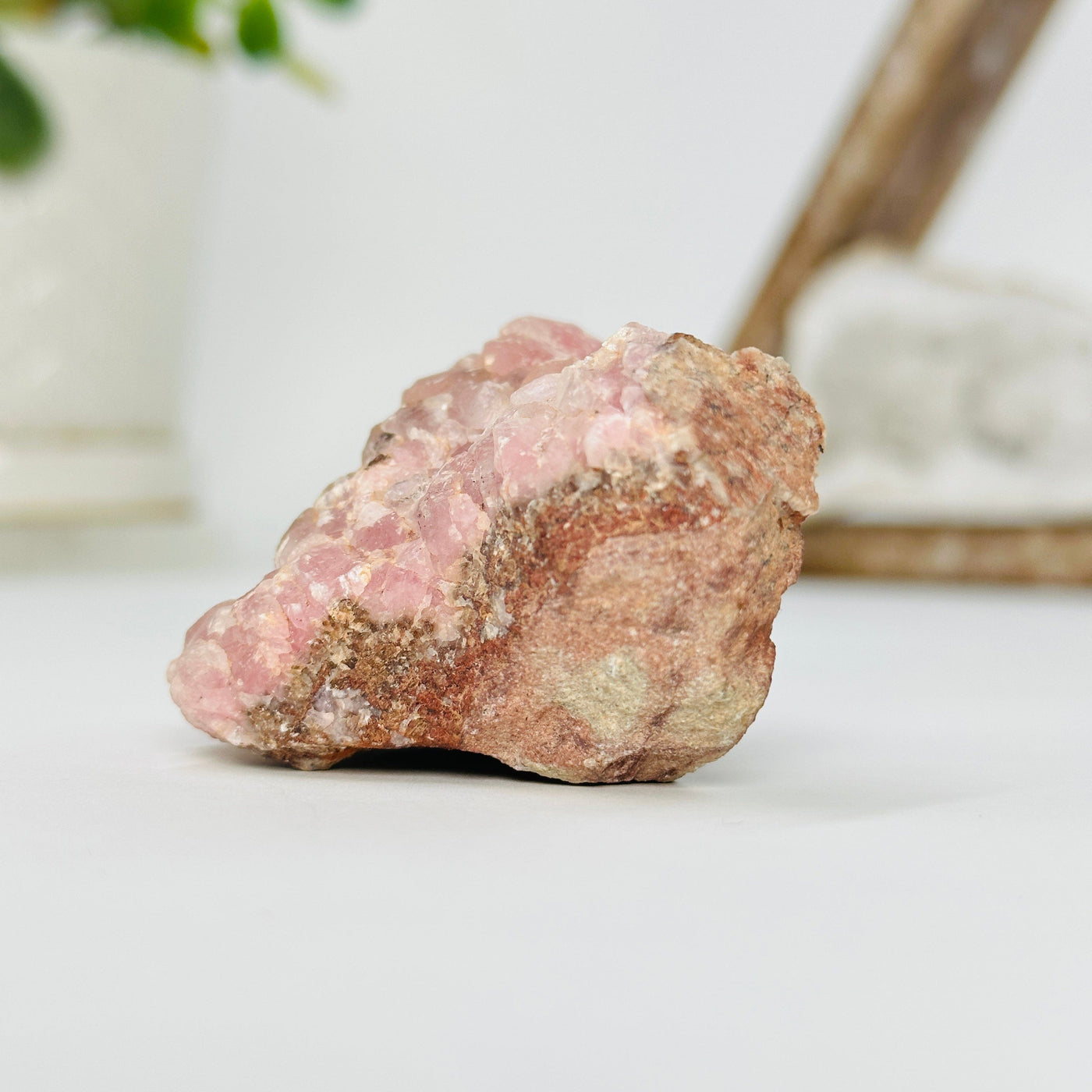pink cobalto calcite formation with decorations in the background