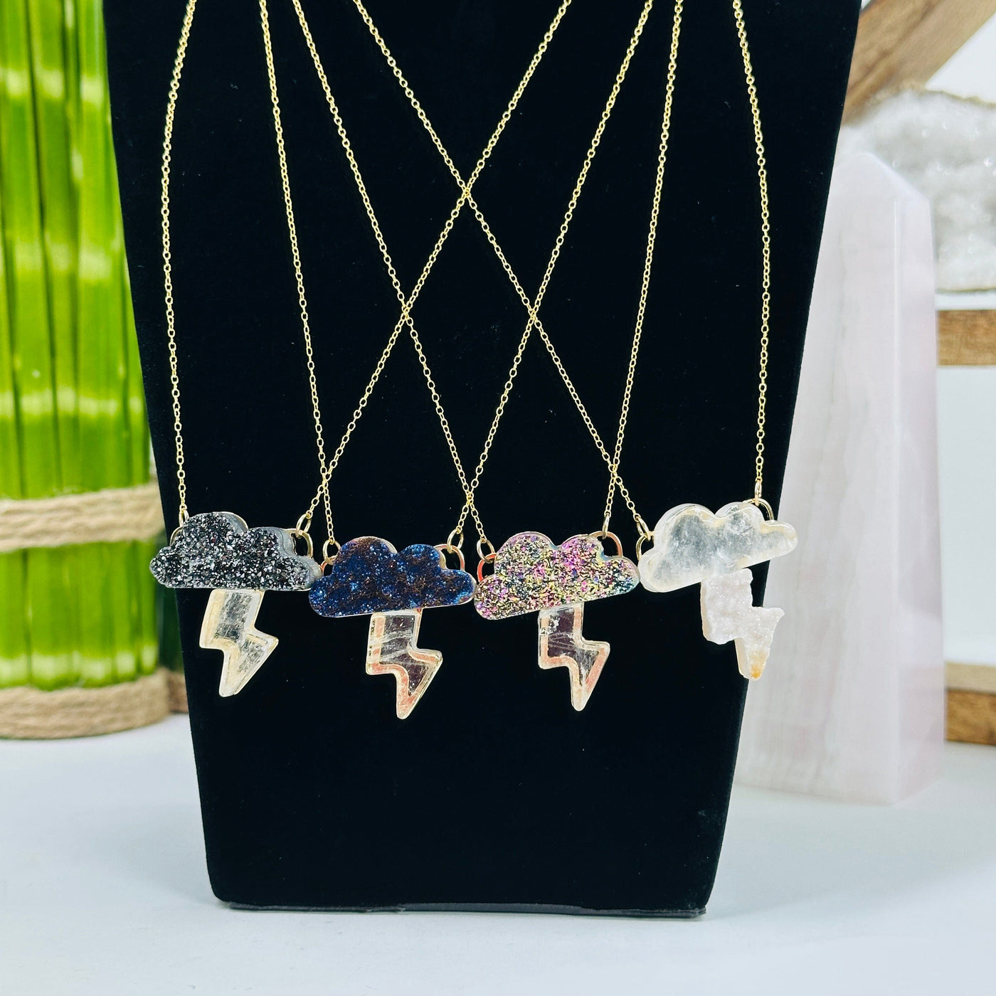 4 cloud with lightning necklaces in gold on a display