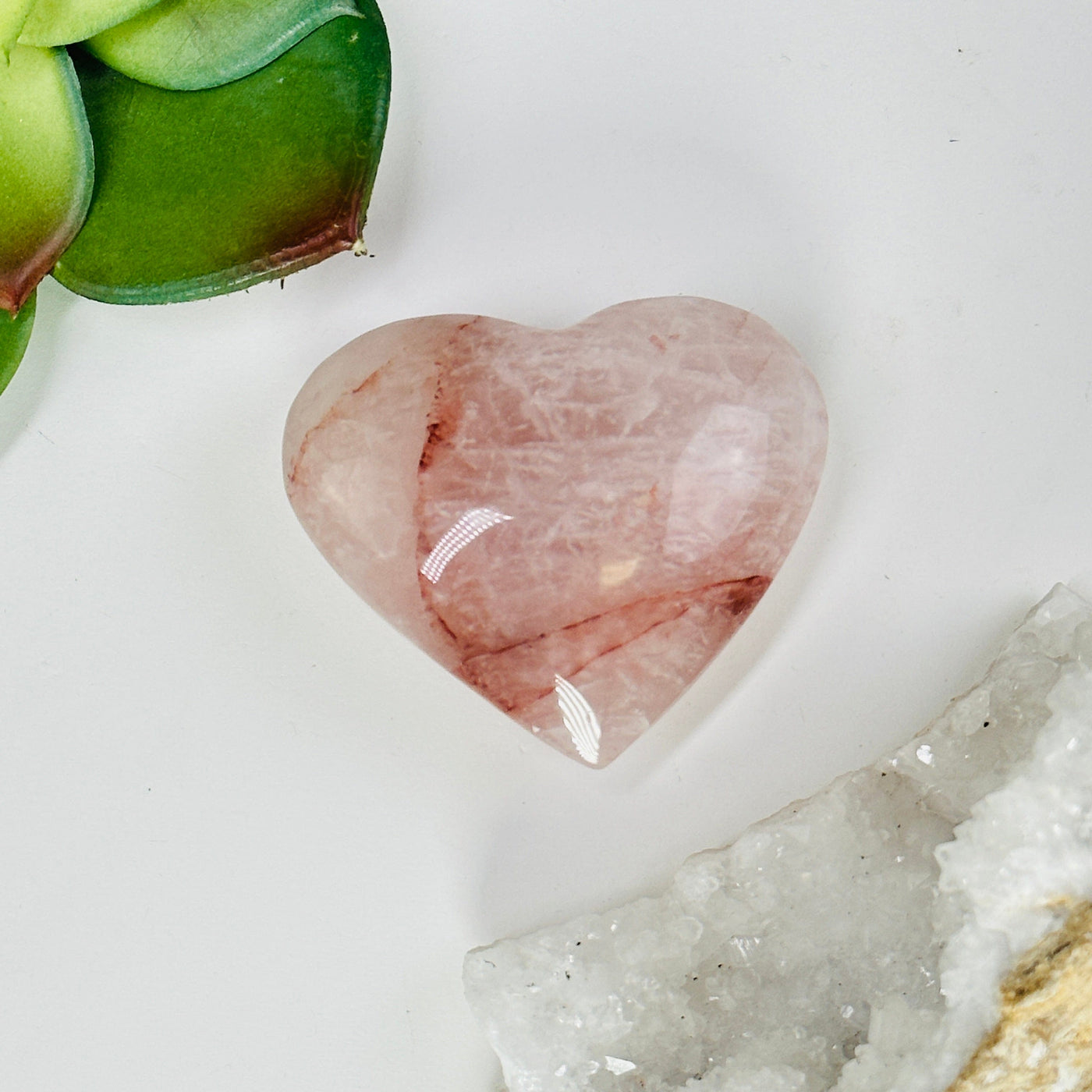 hematoid quartz heart with decorations in the background