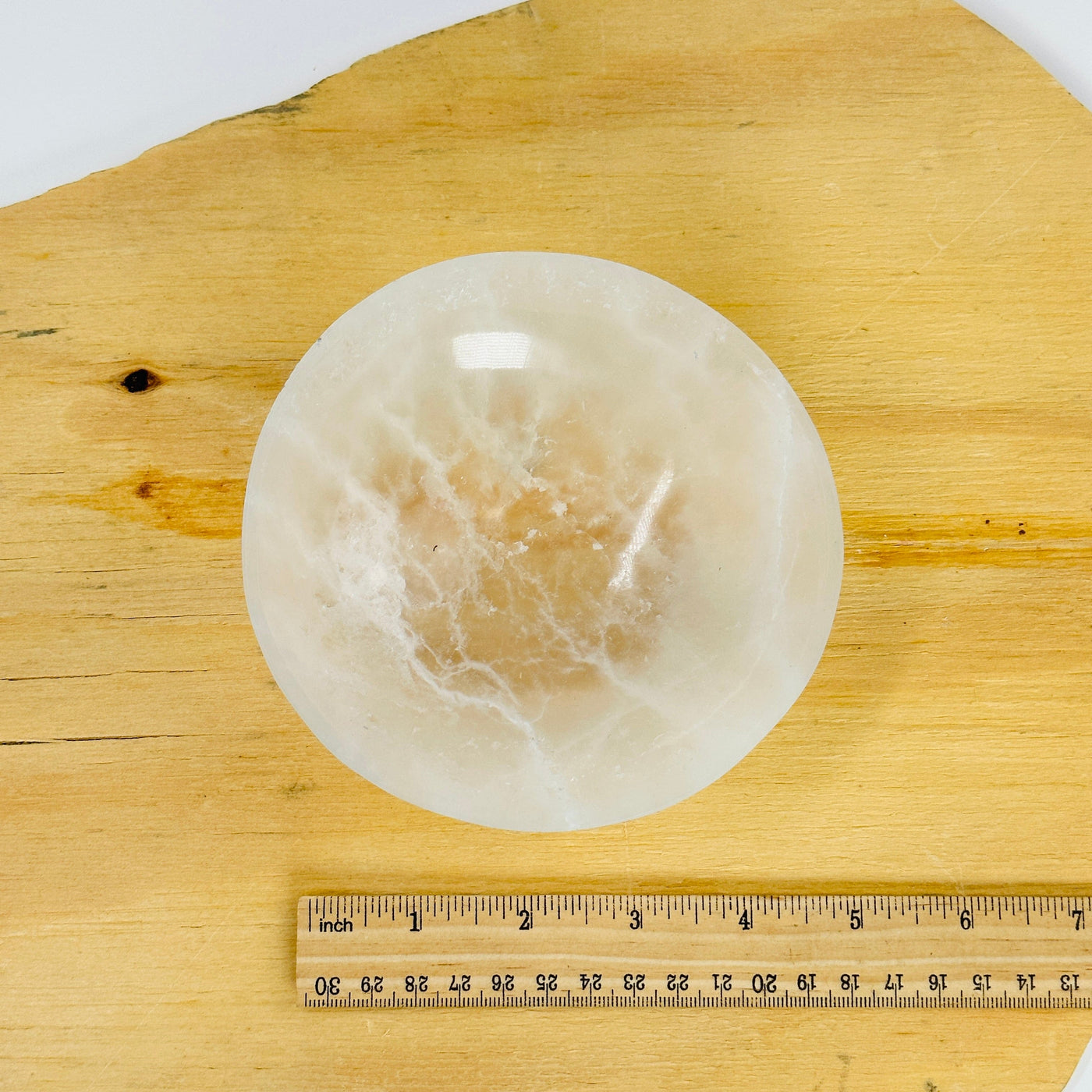 selenite round bowl next to a ruler for size reference