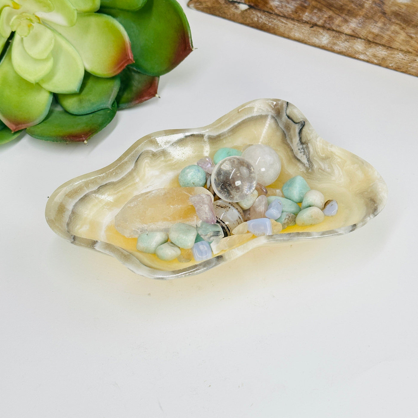 Mexican onyx bowl filled with crystals with decorations in the background