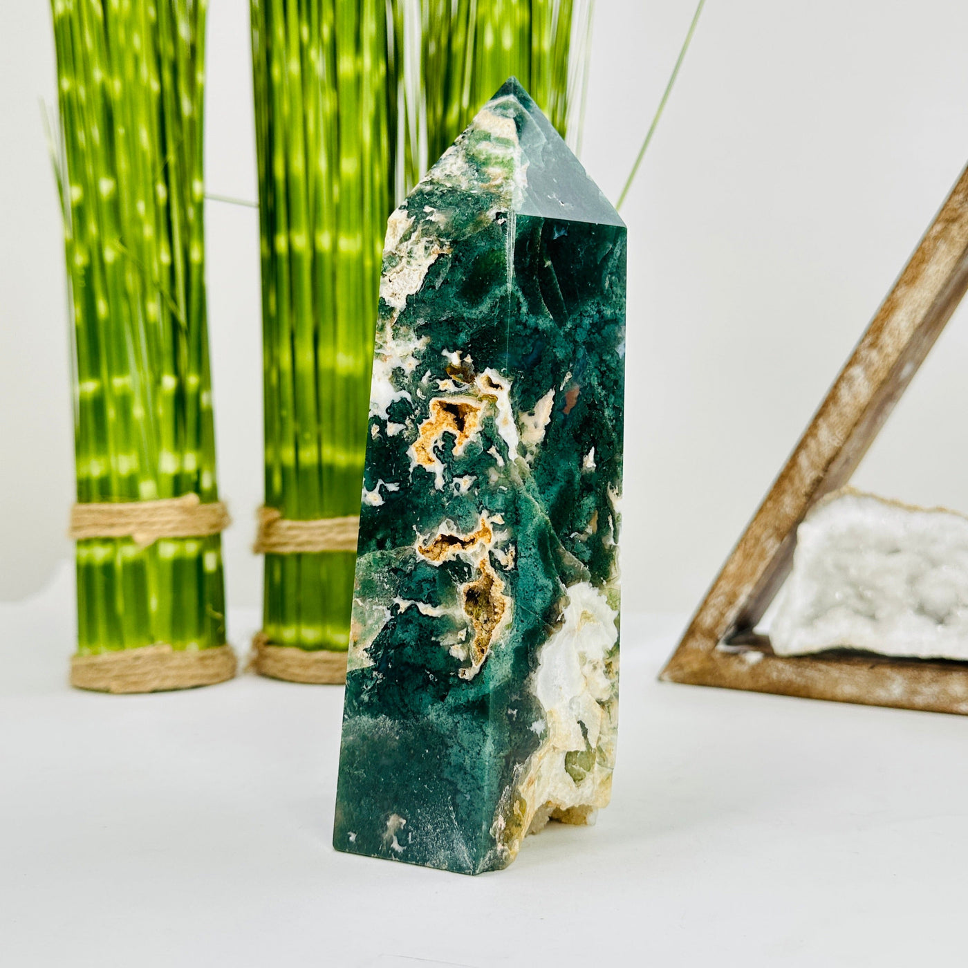 moss agate polished tower with decorations in the background