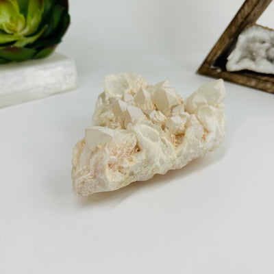 Calcite cluster with decorations in the background
