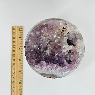 amethyst druzy sphere next to a ruler for size reference