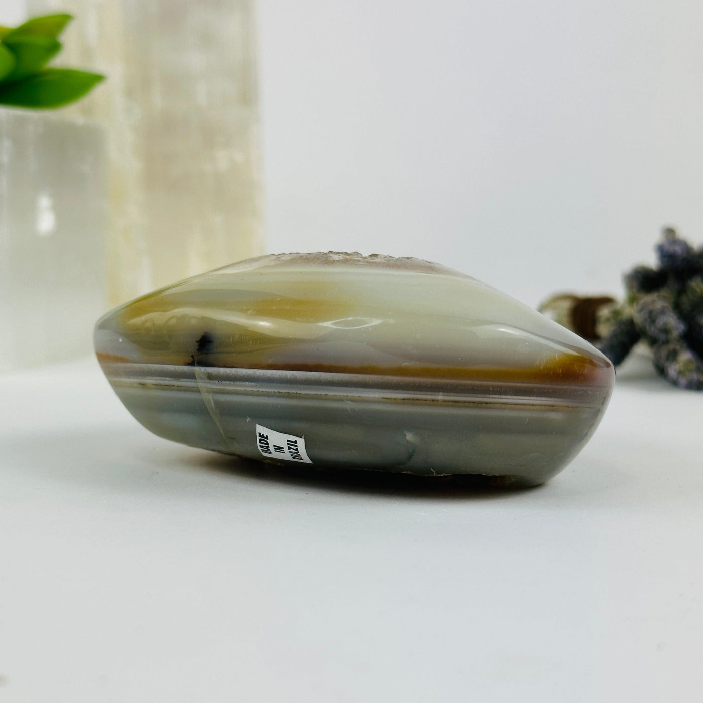 Side view of agate heart with decorations in the background