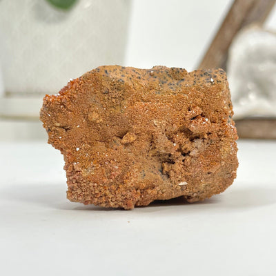 backside of Natural vanadinite freeform with decorations in the background