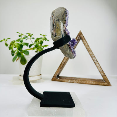 amethyst on metal stand with decorations in the background