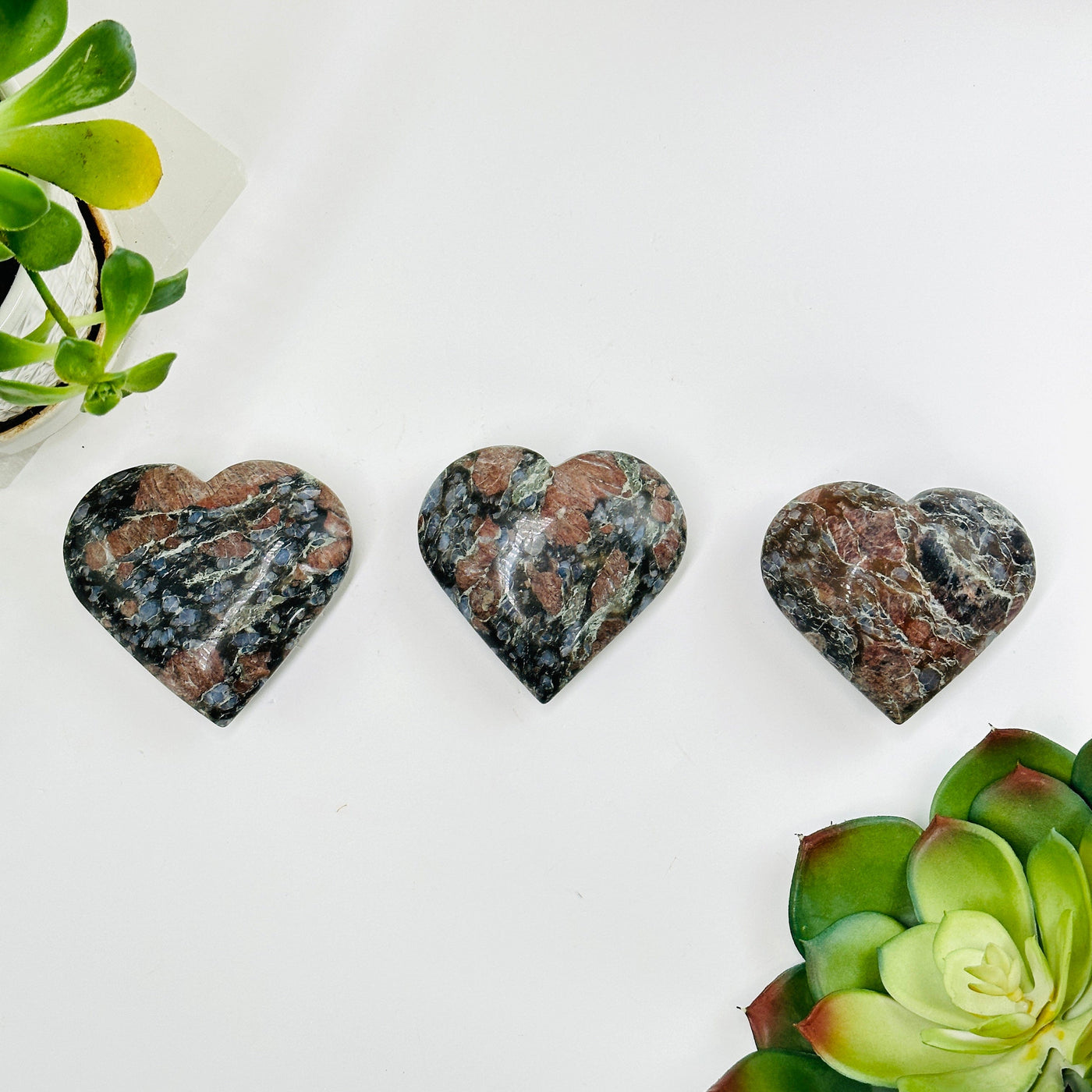 3 rhyolite hearts with decorations surrounding them